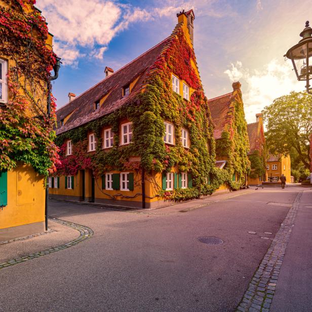 Eine malerische Straße in einer Altstadt, gesäumt von mit Efeu bewachsenen Häusern.