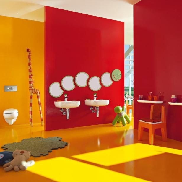 Ein farbenfrohes Badezimmer in Gelb und Rot mit verspielten Details wie einer Giraffe und einem Raupen-Spiegel.