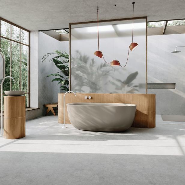 Ein modernes Badezimmer mit freistehender Badewanne und großen Fenstern mit Blick ins Grüne.