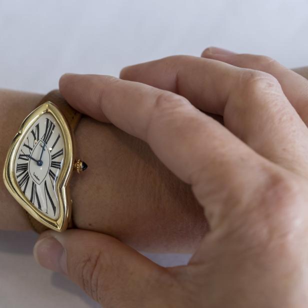 Eine Frau trägt eine Cartier Crash Uhr am Handgelenk.