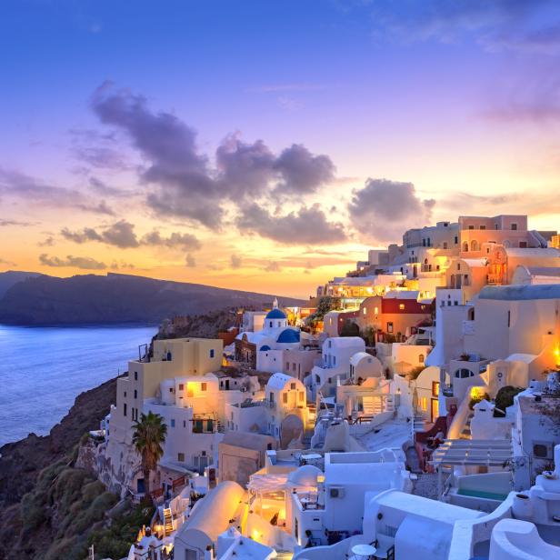 Blick auf die weiß getünchten Häuser von Santorin bei Sonnenuntergang.