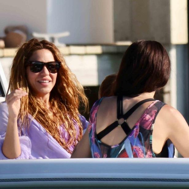 Shakira mit Sonnenbrille und einer Begleiterin auf einem Boot.
