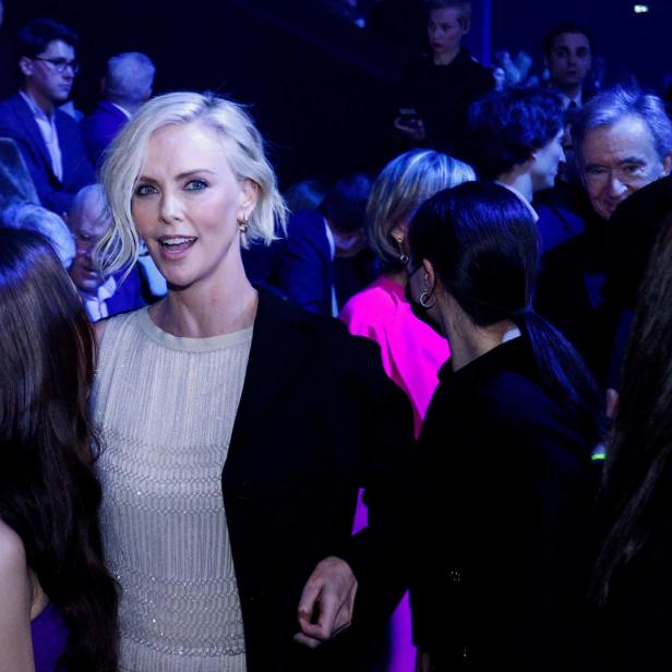 Charlize Theron inmitten einer Menschenmenge bei einer Veranstaltung.