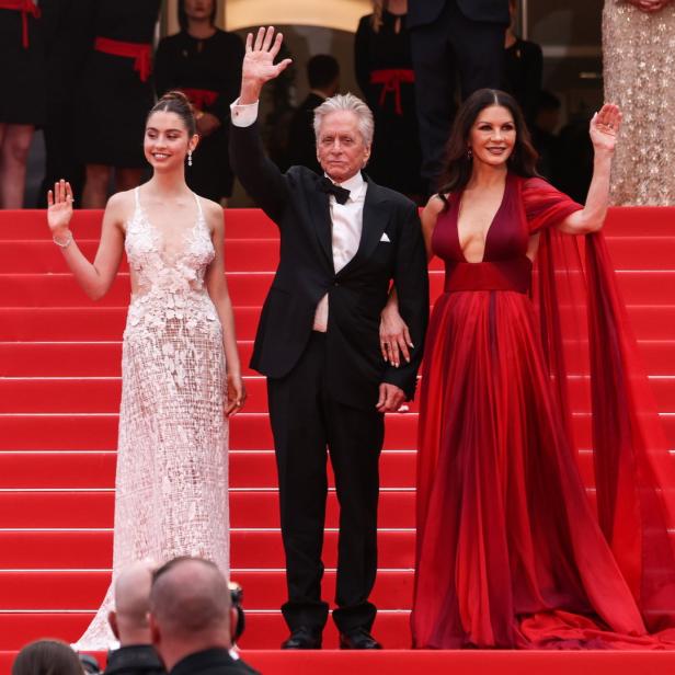Michael Douglas, Catherine Zeta-Jones und ihre Tochter auf einer roten Treppe.