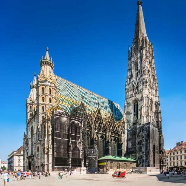 Der Stephansdom in Wien mit seinem markanten Dach und dem hohen Turm unter blauem Himmel.