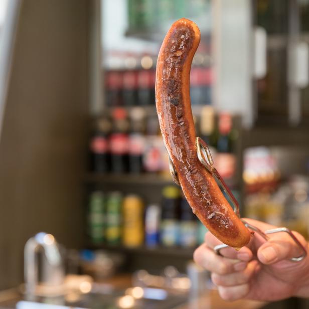 Gebratene Wurst bei einem Wiener Würstelstand.