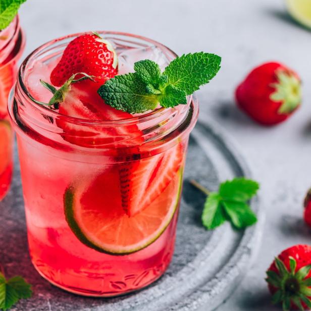 Ein Glas mit einem erfrischenden Erdbeer-Limetten-Getränk, garniert mit Minze.