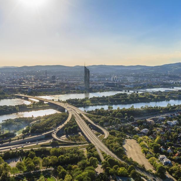 Luftaufnahme von Wien mit der Donau und der Donau City im Hintergrund.