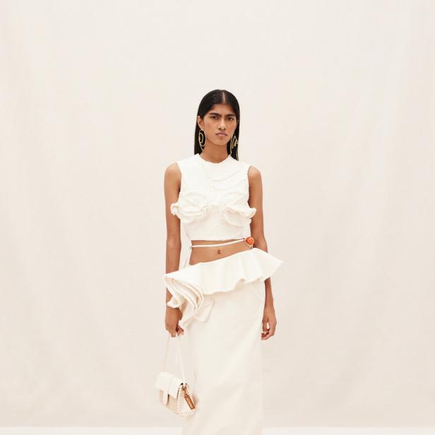 Ein Model präsentiert ein zweiteiliges, weißes Outfit von Jacquemus.