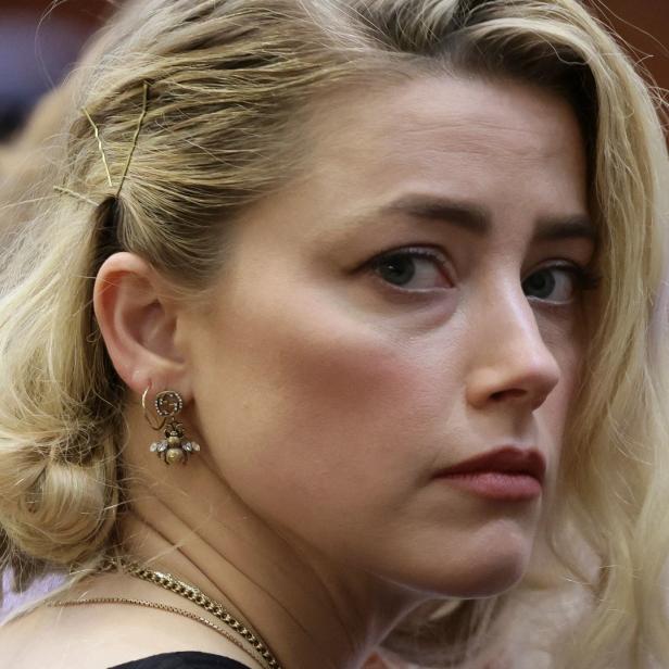 Nahaufnahme von Amber Heard mit blonden Haaren und Bienenohrringen.