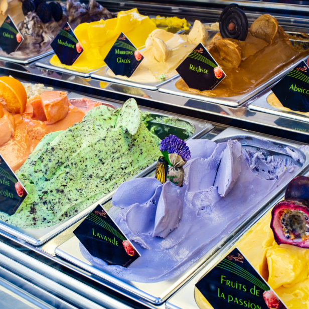 Verschiedene Eissorten, darunter Lavendel, Minze-Schokolade und Passionsfrucht, werden in einem Kühlregal ausgestellt.
