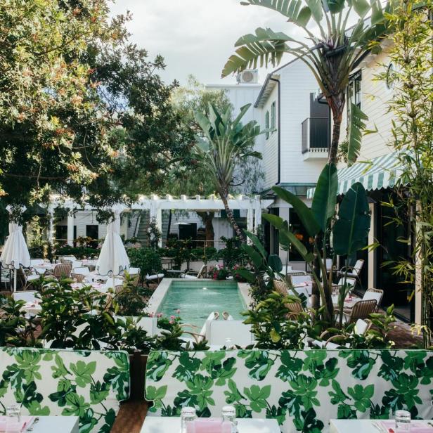 Ein Restaurantgarten mit Tischen, Stühlen und einem kleinen Pool.