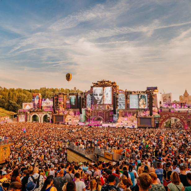 Eine riesige Menschenmenge versammelt sich vor einer aufwendigen Bühne auf einem Musikfestival.