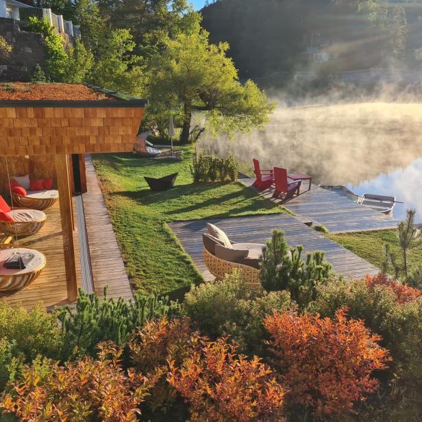 Ein Resort am See mit Nebel über dem Wasser bei Sonnenaufgang.