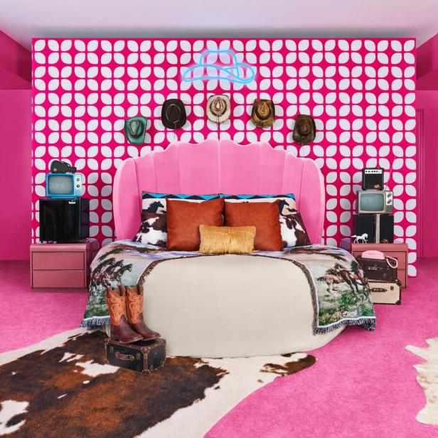 Ein pinkfarbenes Schlafzimmer mit Cowboy-Dekor, inklusive Stiefel, Hüte und Kuhfellteppich.