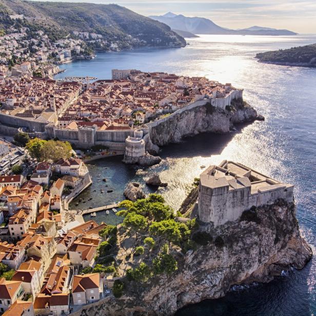 Die Altstadt von Dubrovnik, umgeben von einer steinernen Stadtmauer, liegt an der Küste.