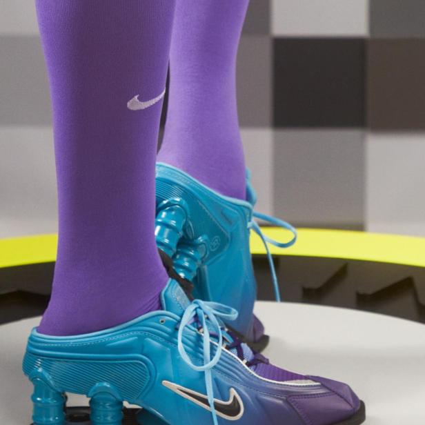 Nahaufnahme von blauen Nike Shox Mule MR4 mit lila Socken.