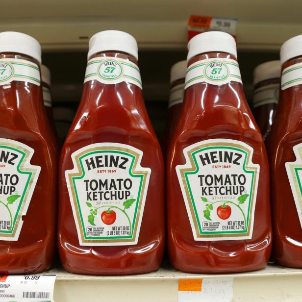 Mehrere Flaschen Heinz Tomatenketchup stehen in einem Regal.