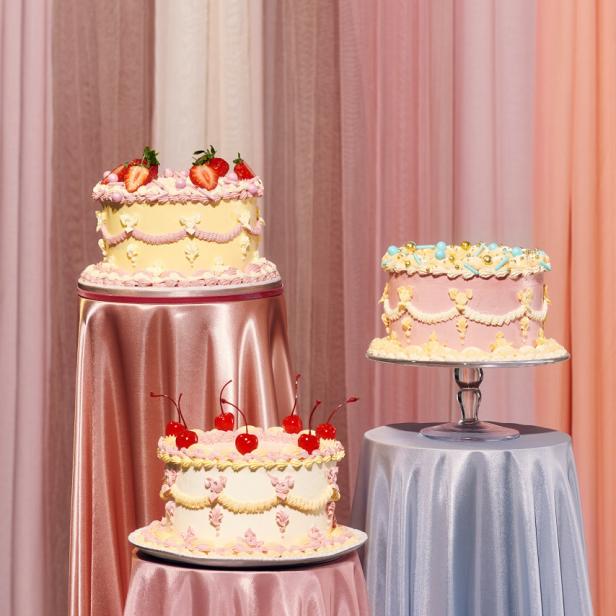 Drei verzierte Kuchen stehen auf Tischen mit pastellfarbenen Tischdecken.