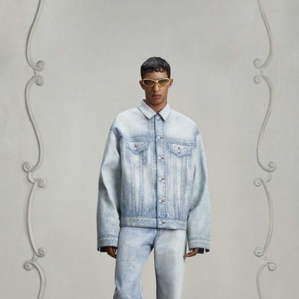 Ein Mann mit Sonnenbrille trägt ein Jeansjacke und Jeanshose.
