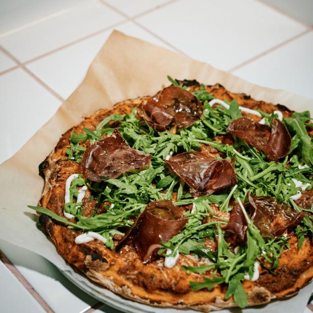 Pizza belegt mit Rucola und XO Beef.