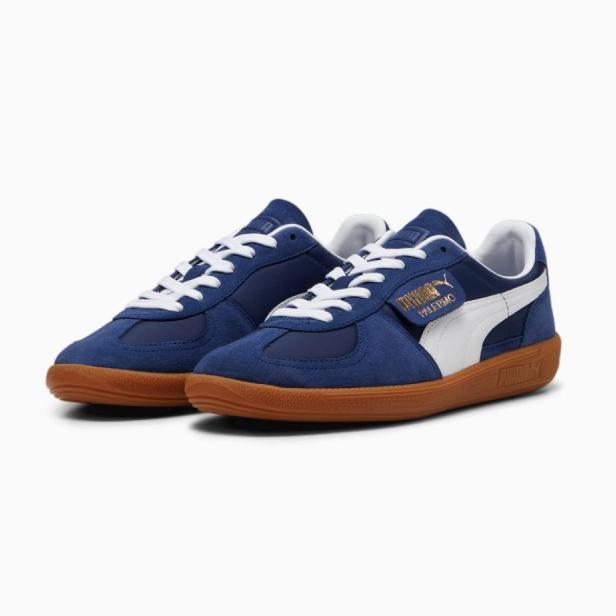 Zwei blaue Puma Palermo-Sneaker mit weißen Schnürsenkeln und Sohlen in Gummioptik.