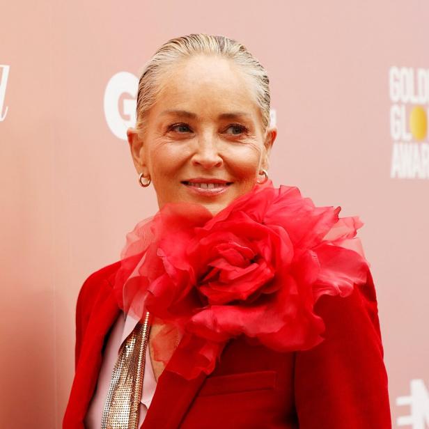 Sharon Stone trägt ein rotes Jackett mit einer großen roten Stoffblume.