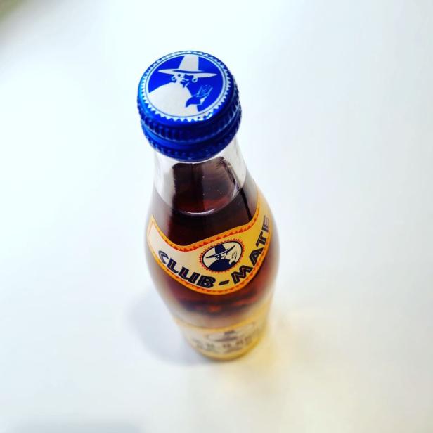Eine Flasche Club-Mate auf einem weißen Hintergrund.