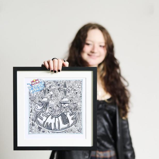 Eine junge Frau präsentiert ein gerahmtes Doodle-Art-Bild von Red Bull.