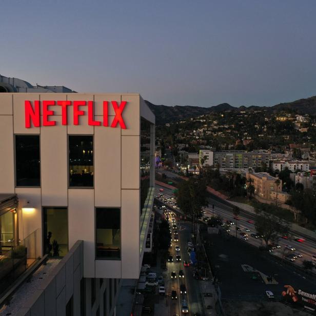 Das Netflix-Logo leuchtet rot auf einem Bürogebäude bei Dämmerung.