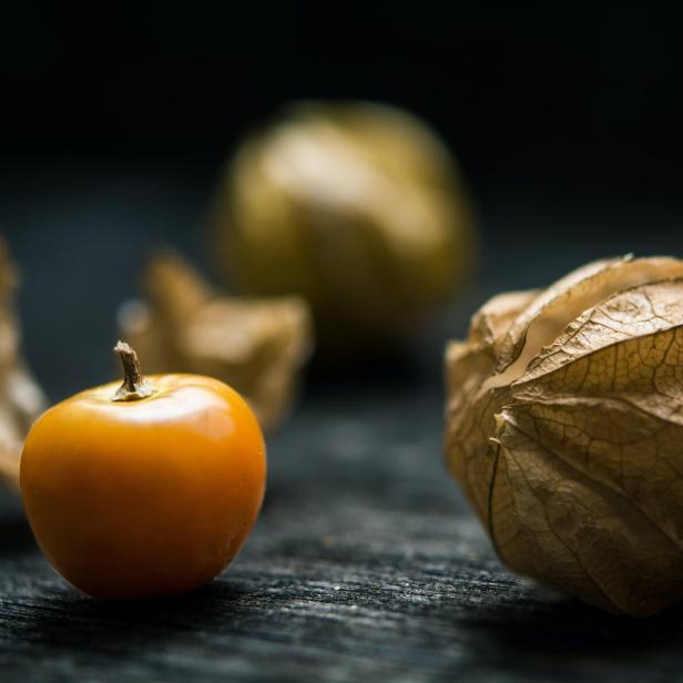 Nahaufnahme einer Physalis mit und ohne Hülle.