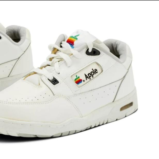 Zwei weiße Sneaker mit dem alten Apple-Logo.