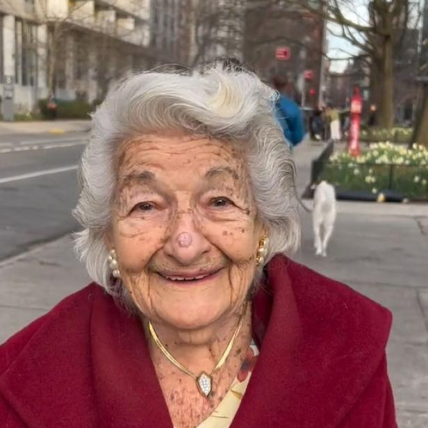 Eine ältere Frau mit weißem Haar lächelt in die Kamera.