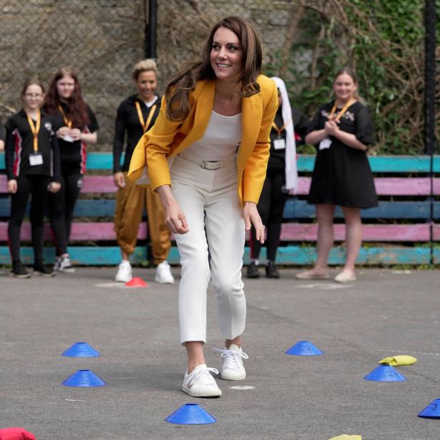 Prinzessin Kate spielt ein Spiel mit Wurfsäckchen und Hütchen vor einer Gruppe von Jugendlichen.