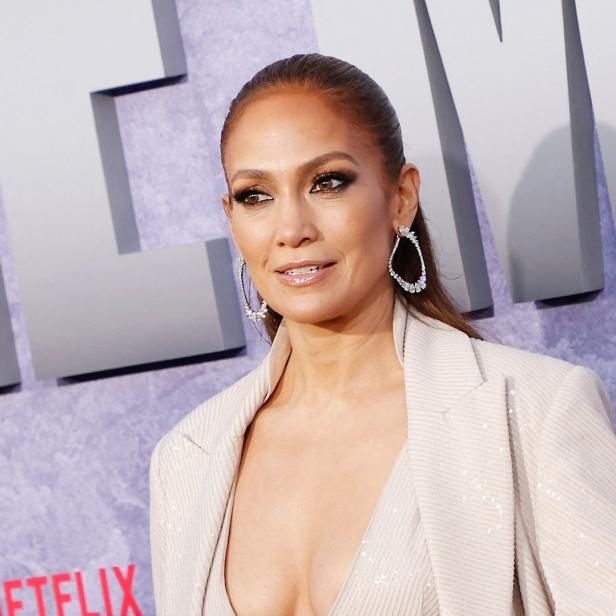 Jennifer Lopez trägt einen Blazer und Ohrringe.