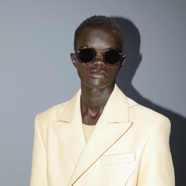 Ein Model mit Sonnenbrille und hellgelbem Blazer von Louis Vuitton.