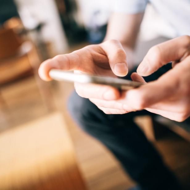 Ein Mann tippt auf einem Smartphone.