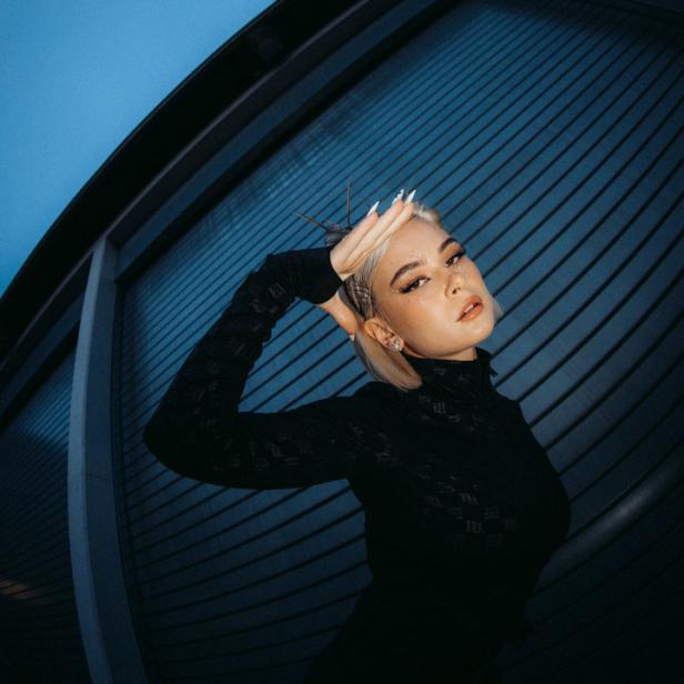 Mathea posiert vor einer blauen Wand für ein Interview.