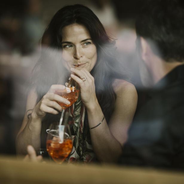 Frau genießt mit ihrem Freund einen Drink in einem Restaurant.