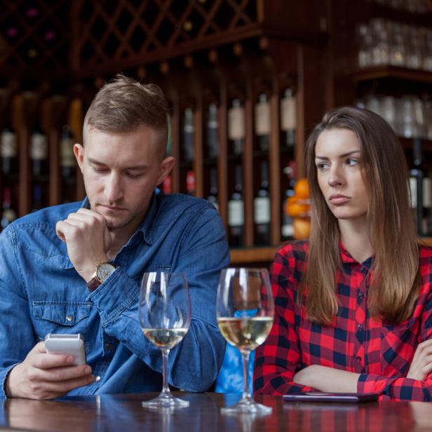 Ein unglückliches Paar sitzt an einem Tisch in einer Bar.