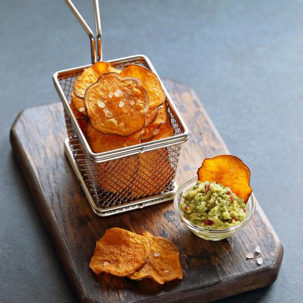 Süßkartoffel-Chips werden mit Guacamole serviert.