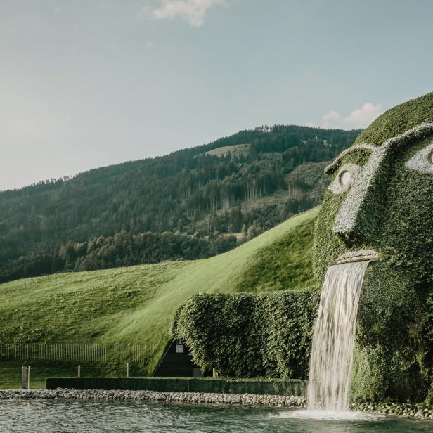 Ein grasbewachsenes Gesicht mit Wasserfall im Swarovski Kristallwelten Park.