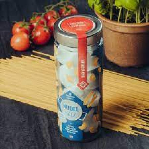 Ein Glas „Bad Ischler Nudelsalz“ steht neben Spaghetti, Tomaten und Basilikum.