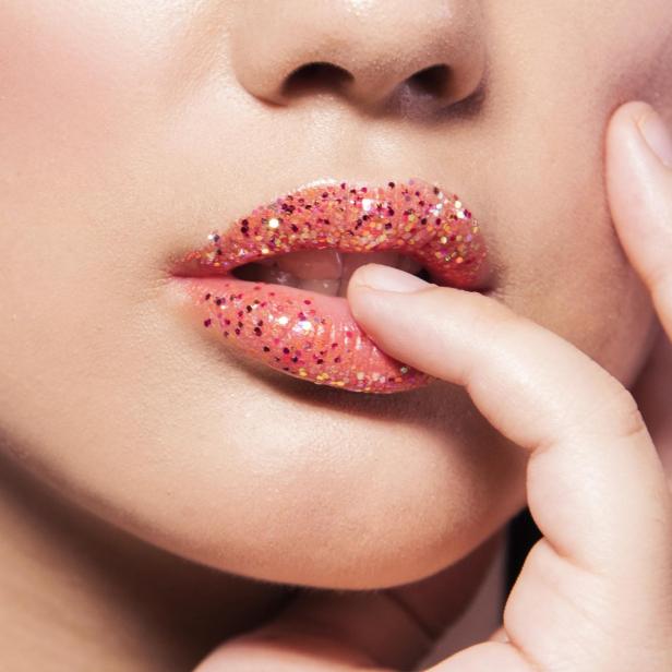Glitzer bedeckt die Lippen einer Frau.