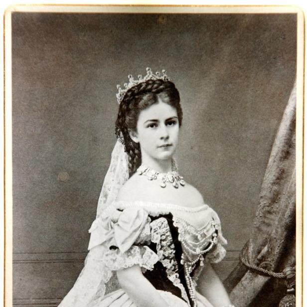 Ein Porträt von Kaiserin Elisabeth von Österreich in einem aufwendigen Ballkleid mit Schmuck und Fächer.