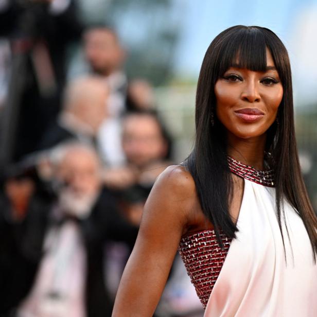 Naomi Campbell in einem weißen Kleid auf dem roten Teppich.
