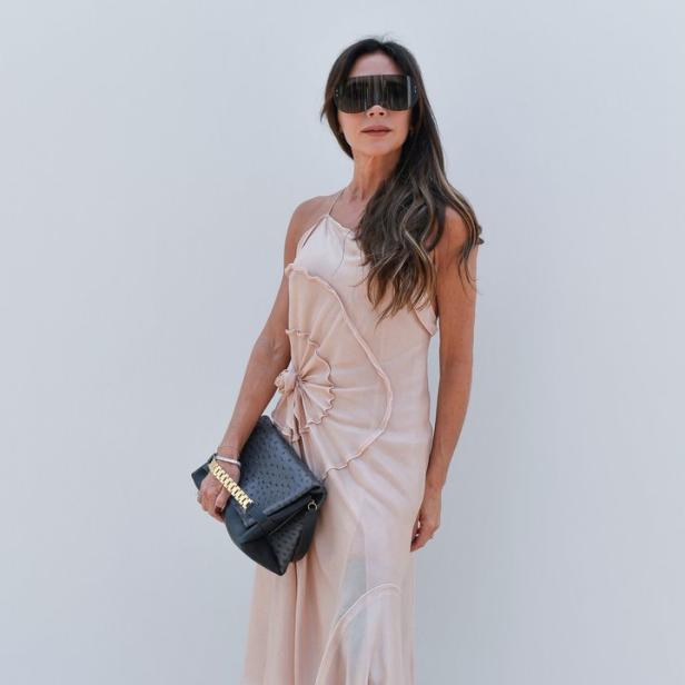 Victoria Beckham trägt ein hellrosa Kleid und eine übergroße Sonnenbrille.
