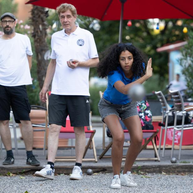 Eine junge Frau spielt Pétanque auf der Summerstage in Wien.