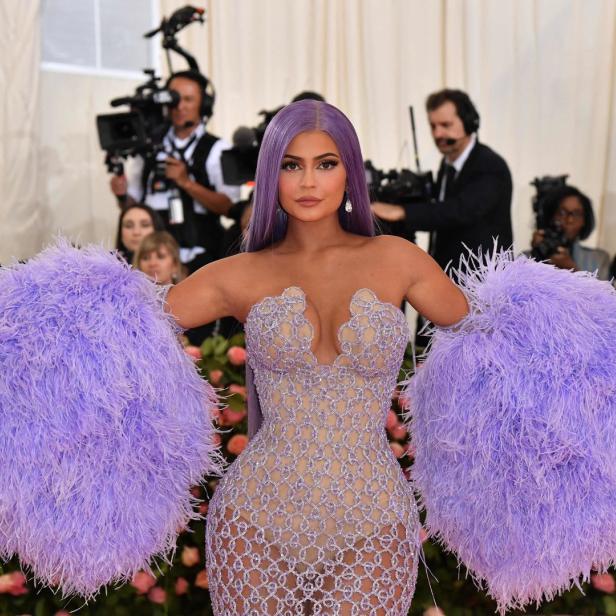 Kylie Jenner in einem aufwendigen, lilafarbenen Federkleid auf dem roten Teppich.