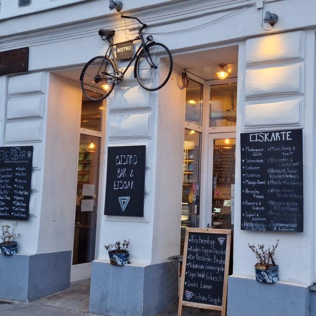 Das „Velobis“ ist Bistro, Bar und Eisbar; ein Fahrrad hängt als Dekoration über dem Eingang.